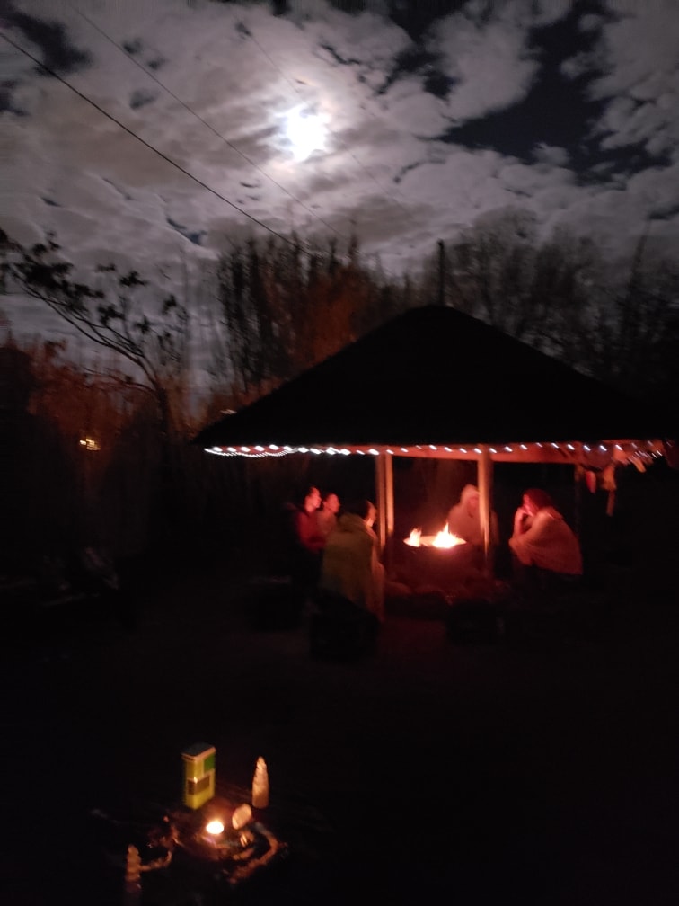 Community gathering around a ceremonial fire under a full moon at the Church of the Spiritual Path, Albuquerque — Kiva ceremony at night